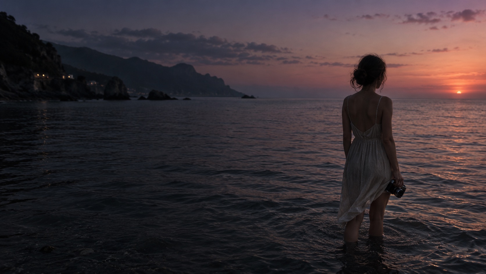 A woman looking out over the sea at sunset